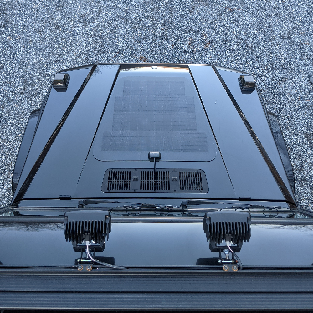 
A black mercedes-benz g-wagen wagon with a hood mounted solar panel system from cascadia 4x4, great for charging accessories while overlanding